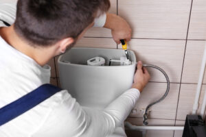 plumber fixing toilet Pat's Plumbing and Gas